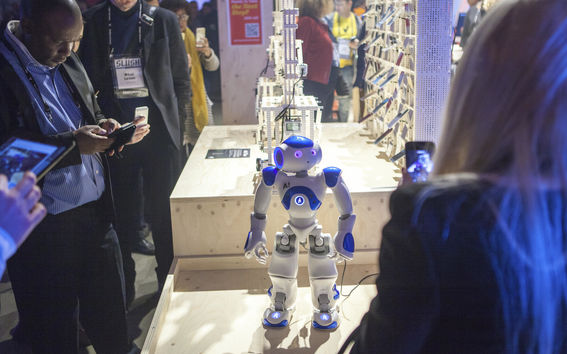 A small white and blue robot pictured on display at Aalto's monter at Slush