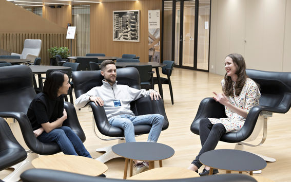 Kolme opiskelijaa istuu rennosti rupattelemassa Kauppakorkeakoululla