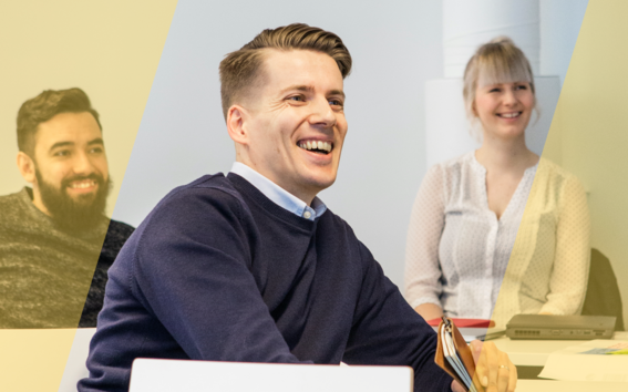 Three students laughing together while listening to a lecture
