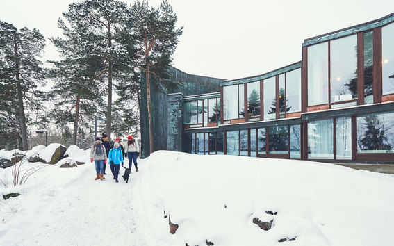 Ryhmä opiskelijoita ja koira talviaikaan Dipolin edustalla.