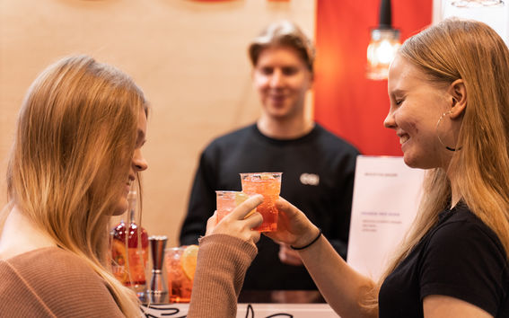 Students enjoying a complementary drink on a stand