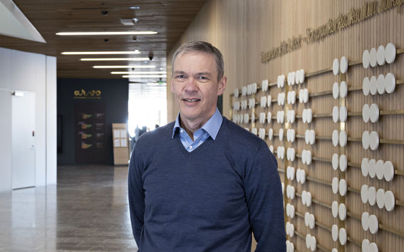 Dekaani Timo Korkeamäki lahjoittajaseinäteoksen edessä. Kuva Roope Kiviranta