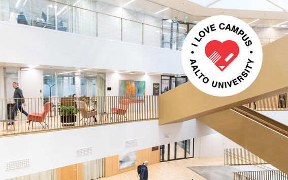 A glimpse inside School of Business building. A person dressed in black walk with a backbag on the first floor towards right and another person walks to the left on the second floor.