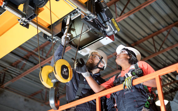 Nainen ja mies huoltavat Konecranesin nosturia. Lähde: Konecranesin kuvapankki