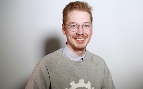 Photo of a person wearing glasses with a goatee smiling into the camera