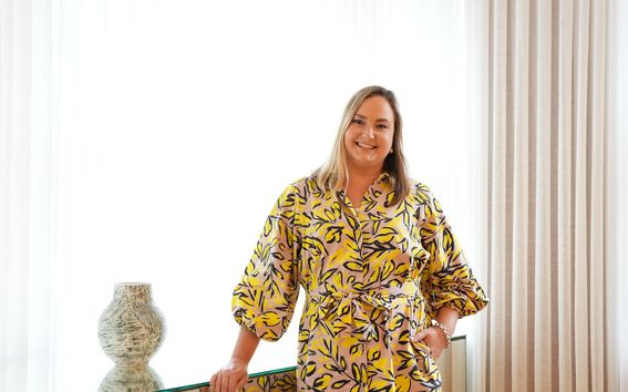 Laura Sivula stands and looks at the camera smiling at Töölö campus