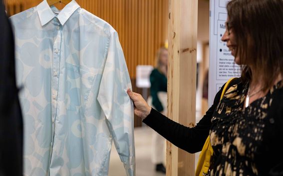 Woman touching a long-sleeved Marimekko Unikko shirt on display