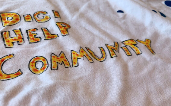 A white t-shirt with Digi help community written with yellow and red markers.
