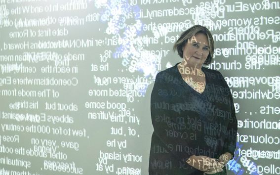 Rafaela Seppälä seisoo keskellä valoteosta, joka muodostuu seinälle heijastetuista englanninkielisistä sanoista. Sanoja kulkee myös Seppälän kasvojen ja vartalon päältä.