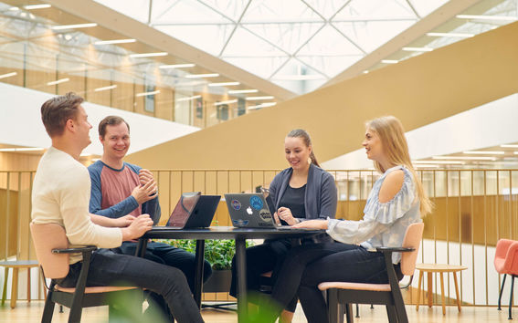 Business students gathered around a table to study together.