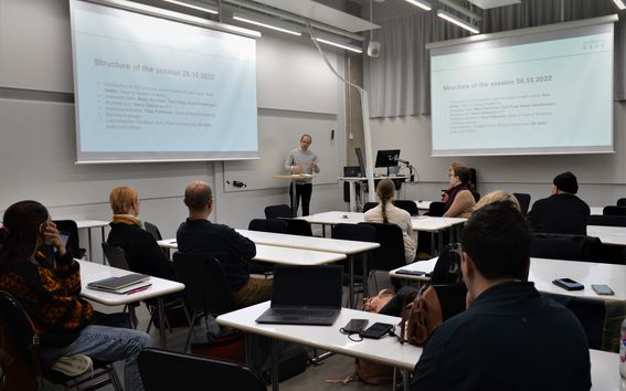 Henkilö luennoi luokan edessä henkilöstön jäsenille 