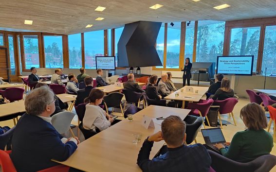 Audience in smaller tables listening to senior university lecturer Leena Lankoski