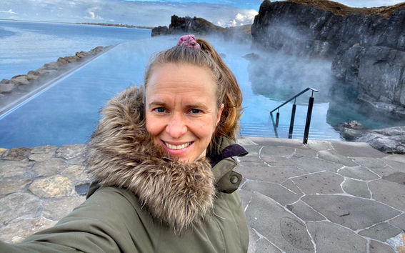 Satu Rämö seisoo islantilaisen kylpylän vesialtaiden edessä. 