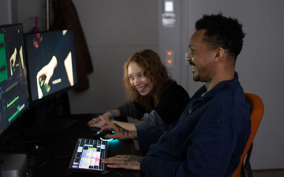 Two students are laughing at the computer.