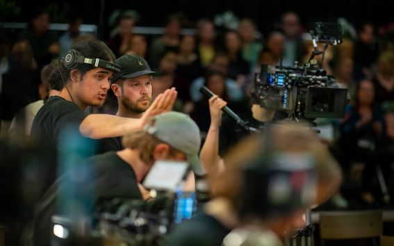 Två studenter pratar bakom kameran.