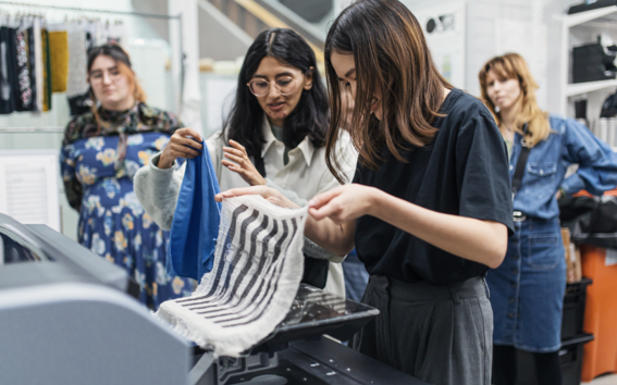 students at the printing workshop holding fabrics with fresh prints