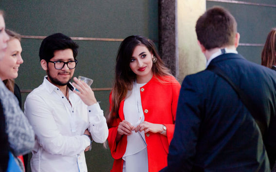 IDBM students standing in a group talking and listening to one another.