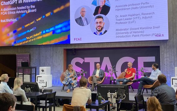 Four seated people on stage having a panel discussion.
