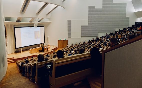 People sitting in a large lecture theatre