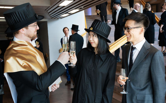 Two doctors raising their glasses to celebrate their promotion to doctors