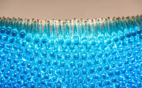 Artworkd from Dipoli, dozens of drop-shaped blue glass artefacts