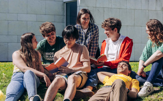 Aalto University students discussing in a group and enjoyng a summer sunny day outside Aalto University campus