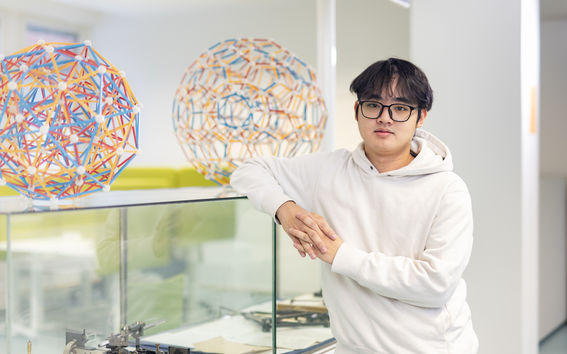 Khanh Thieu Nam standing in next to a shelf