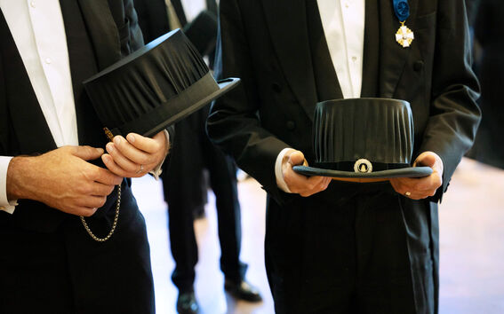 Two persons holding doctor's hats