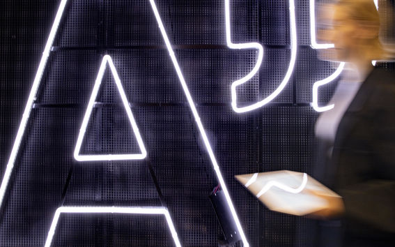 Big Aalto logo light and woman walking past it