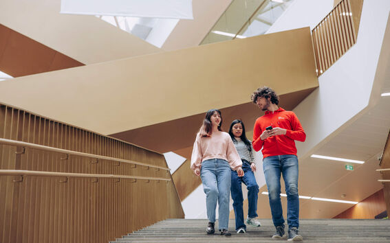 Aalto students walking down the stairs of Aalto University School of Business.