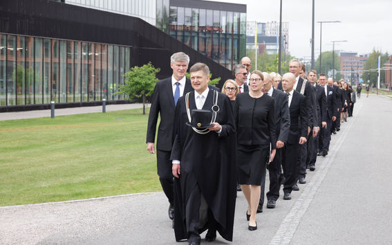A procession of people dressed in dark clothing