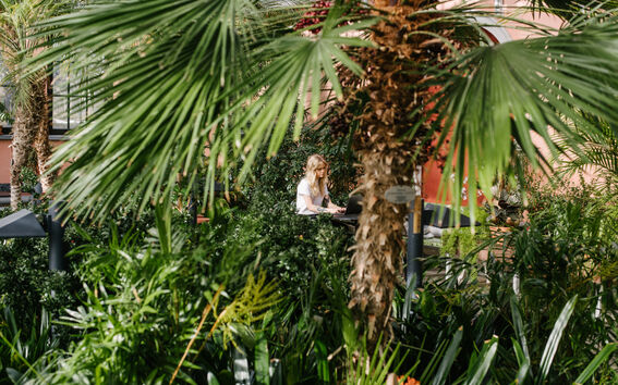 Girl in the middle of plants in the Helsinki city Winter Garden