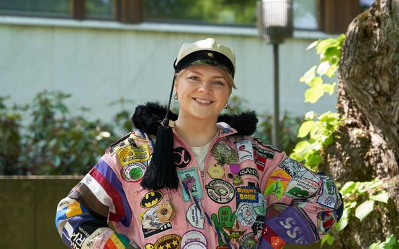 Opiskelija Janni Kerkkänen hymyilee kameralle haalareissaan. 