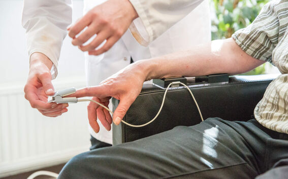 Labratoriossa tutkija mittasi henkilön verenpainetta.