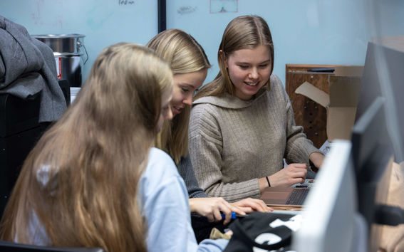 Tre studenter arbetar med sina projektarbeten i kursen Sähköpaja. 