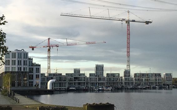 Cranes building houses on the waterfront