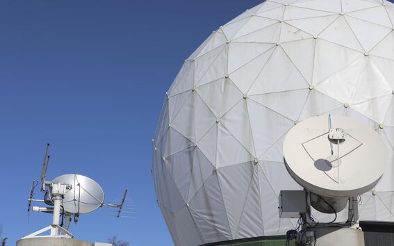 Lähikuva radioteleskoopin kuvusta sinistä taivasta vasten.