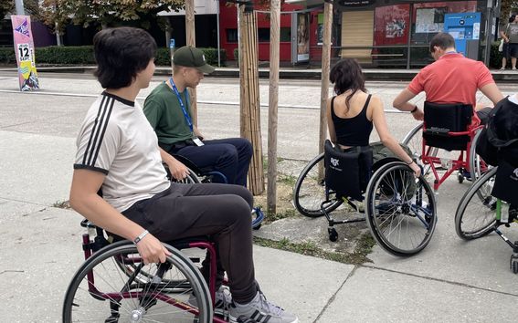 Students in wheel chairs in an urban environment.