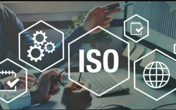 Two people discussing with ISO-related icons overlayed, including gears, a globe, and checkmarks, in an office setting.