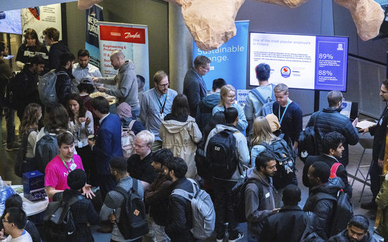 Kuva Thesis Day -tapahtumasta vuodelta 2024. Kuvassa näkyy työnantajien edustajia ja opiskelijoita, jotka etsivät lopputyöprojektia. 