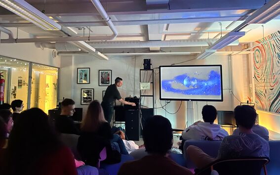 Students attending a Smoothies & Movies film screening in Space 21. The host it setting up the movie.