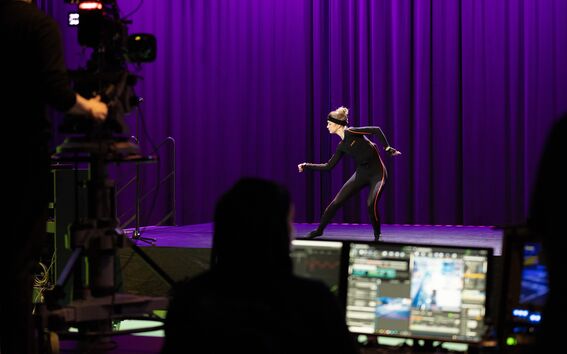 A dancer performing in a motion capture studio setting