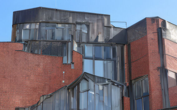 Tekoälyn avulla muokattu kuva sinitaivaan alla olevasta punatiilirakennuksen ikkunanurkkauksesta, jossa on epäsäännölliset ikkunat.