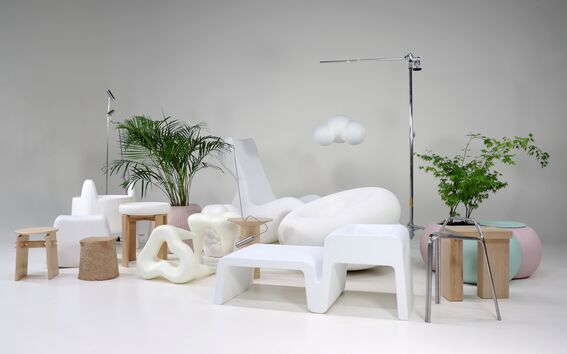 Moderni huone, jossa on erikoisia valkoisia tuoleja, puisia jakkaroita, lehtikasveja ja pilven muotoinen roikkuva lamppu.