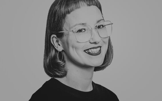 Person with short hair, black round-neck shirt, and glasses.