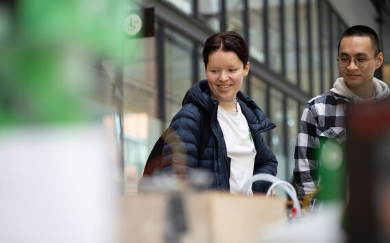 Kaksi opiskelijaa katsoo elektronisia laitteita