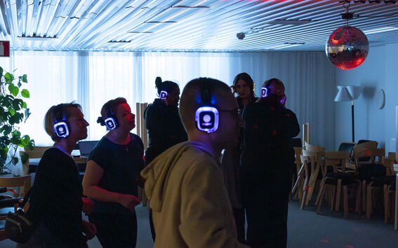 Ihmisiä tanssimassa kuulokkeet päässä.