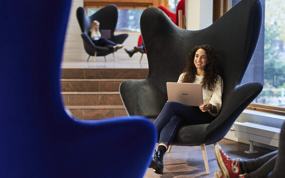 Woman sitting in an armchair with computer