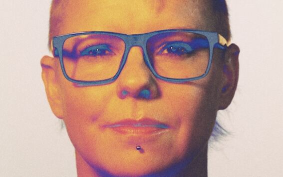 Person with short, styled hair wearing a blue shirt.