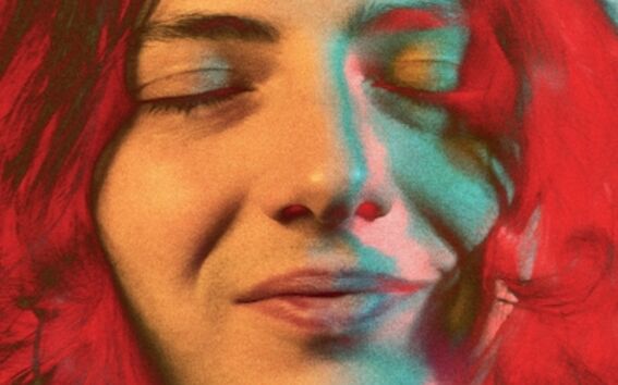 A person with long, wavy hair against a light blue background.